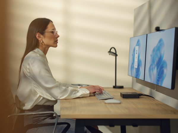 Woman working at a desktop computer with two monitors